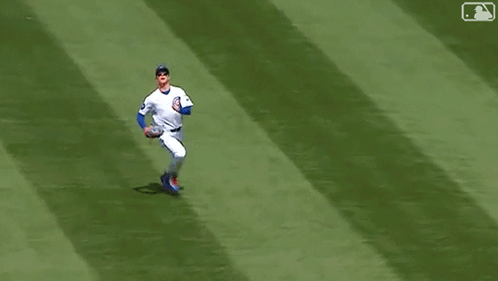 A Baseball Player Is Laying On The Field With His Feet Up . GIF