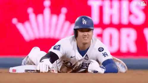 A Baseball Player Is Laying On The Ground In Front Of A Sign That Says This For 1 GIF