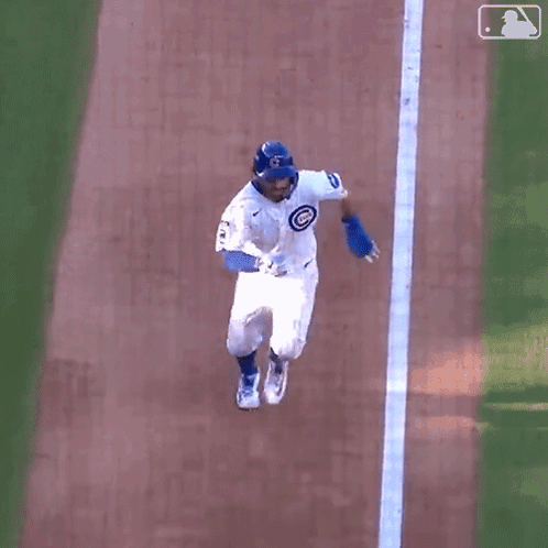 A Baseball Player Is Laying On The Ground On His Back . GIF