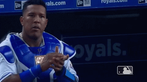 A Baseball Player Is Pointing At The Camera In Front Of A Royals Sign GIF
