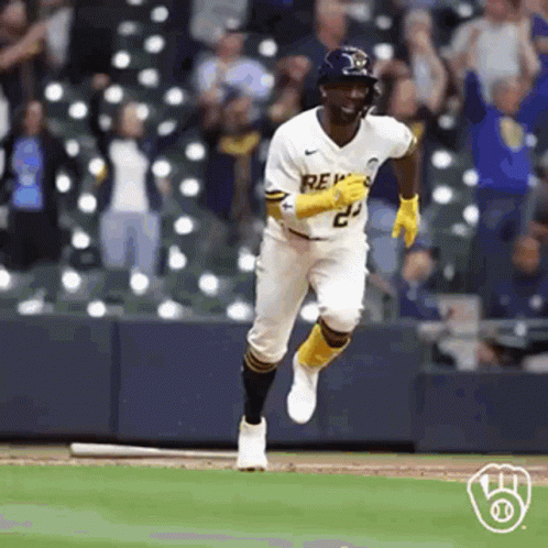 A Baseball Player Is Running On A Baseball Field With A Bat . GIF