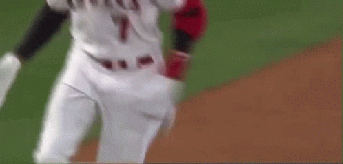 A Baseball Player Is Running On A Baseball Field With A Bat In His Hand . GIF