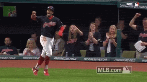 A Baseball Player Is Running On The Field With A Mlb.com Logo Behind Him GIF