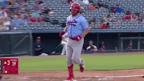 A Baseball Player Is Running To First Base During A Baseball Game . GIF