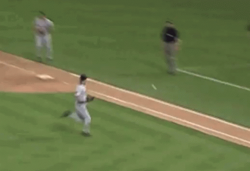 A Baseball Player Is Running Towards A Base While A Catcher Is Kneeling Down . GIF