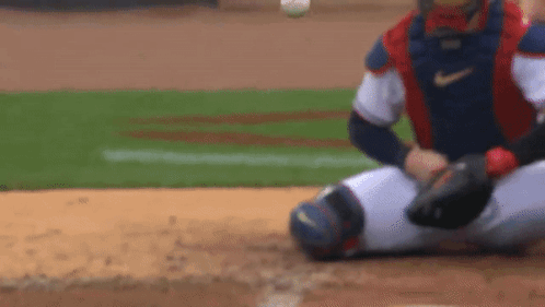 A Baseball Player Is Sitting On The Ground Waiting For The Ball To Be Thrown To Him . GIF