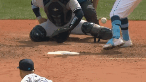 A Baseball Player Is Sliding Into Base While The Catcher Watches GIF