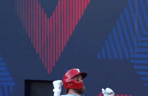 a baseball player is standing in front of a scoreboard .