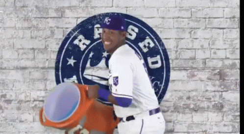 A Baseball Player Is Standing In Front Of A Sign That Says Kc GIF