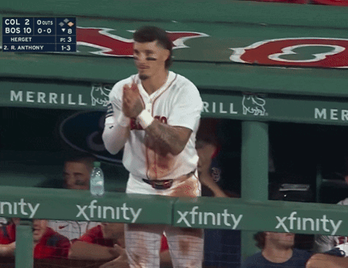 a baseball player is standing in the dugout with blood on his shirt and a sign that says xfinity