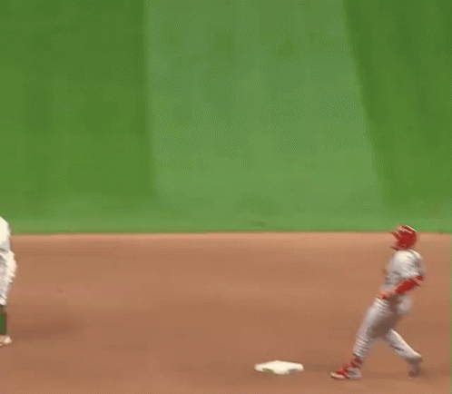 A Baseball Player Is Standing On A Base On A Field . GIF