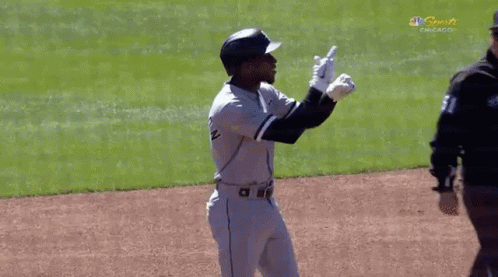 A Baseball Player Is Standing On A Field With His Arms In The Air . GIF