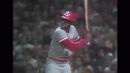 A Baseball Player Is Swinging A Bat At A Ball In A Baseball Game . GIF