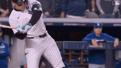 A Baseball Player Is Swinging A Bat At A Pitch During A Baseball Game . GIF