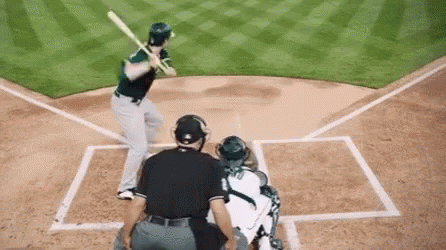 A Baseball Player Is Swinging A Bat At A Pitch While A Catcher Watches . GIF