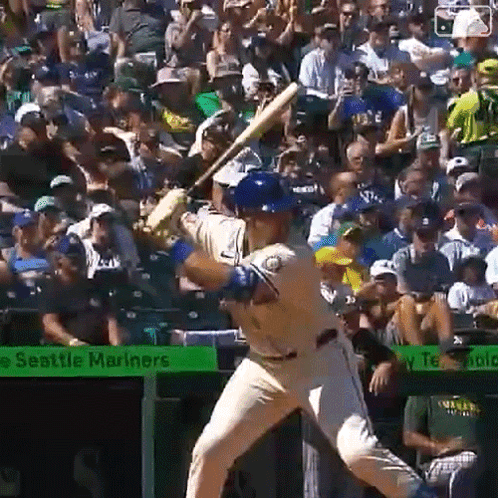 A Baseball Player Is Swinging At A Pitch In Front Of A Seattle Mariners Banner GIF