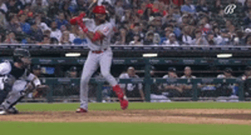 A Baseball Player Is Swinging His Bat At A Pitch During A Game GIF