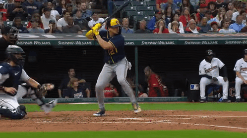 A Baseball Player Is Swinging His Bat At A Pitch In Front Of A Sherwin-Williams Banner GIF