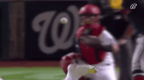 A Baseball Player Is Trying To Catch A Ball While A Catcher Is Trying To Catch The Ball . GIF