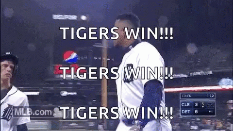 A Baseball Player Is Walking Towards The Dugout With The Words `` Tigers Win !!! '' Written On The Screen . GIF