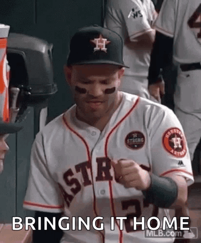 A Baseball Player Is Wearing A Hat And A Jersey And Is Sitting In The Dugout . GIF