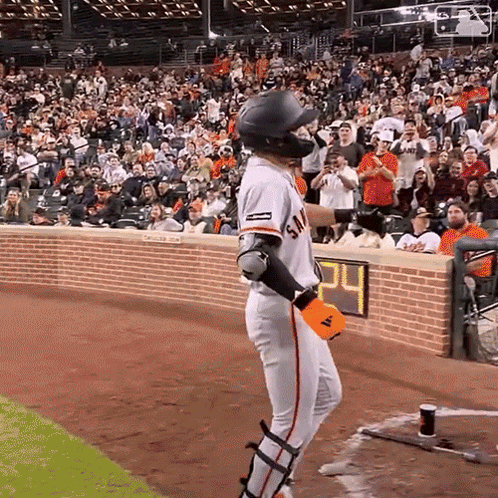 A Baseball Player Stands In Front Of A Crowd With The Number 24 On The Wall Behind Him GIF