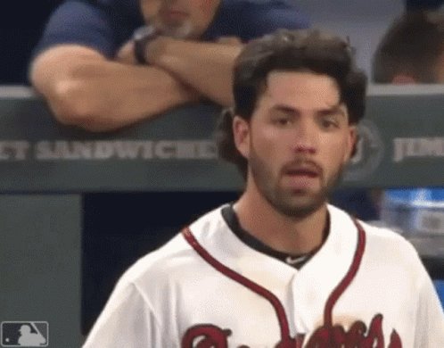 A Baseball Player Stands In Front Of A Dugout That Says Jimmy Sandwiches GIF