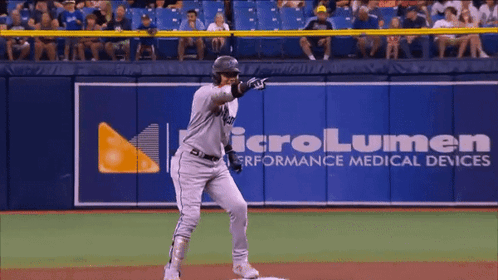 A Baseball Player Stands In Front Of A Microlumen Advertisement GIF