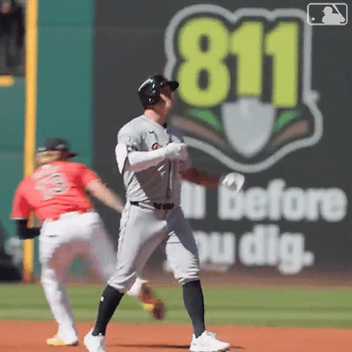 A Baseball Player Stands On The Field In Front Of A 911 Sign GIF