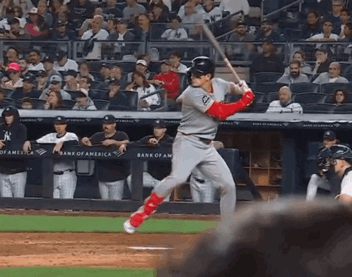 A Baseball Player Swings At A Pitch In Front Of A Bank Of America Sign GIF