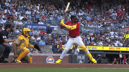 A Baseball Player Swings At A Pitch In Front Of A Gulf Advertisement GIF