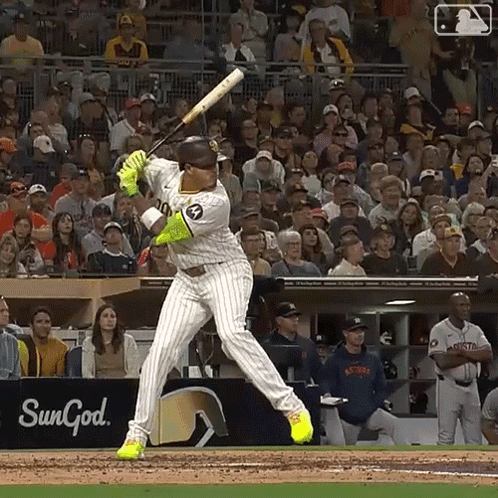 A Baseball Player Swings At A Pitch In Front Of A Sungod Sign GIF
