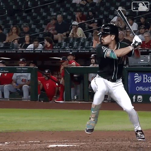 A Baseball Player Swings His Bat At A Ball In Front Of A Banner That Says Ba GIF