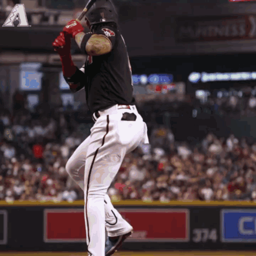 A Baseball Player Swings His Bat At A Ball In Front Of A Sign That Says 374 GIF