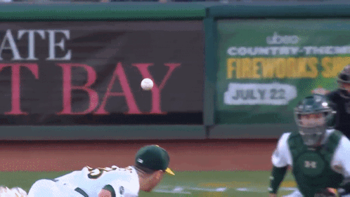 A Baseball Player Throws The Ball In Front Of A Sign That Says Fireworks GIF