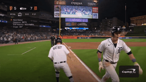 A Baseball Player Wearing A Bat Boy Jersey Is Running Towards The Base GIF
