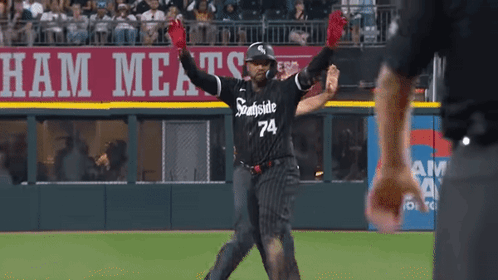 A Baseball Player Wearing A Black And White Uniform With The Number 74 On It GIF