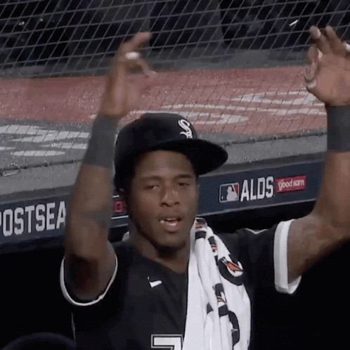 A Baseball Player Wearing A Black Hat And A White Scarf With The Number 7 On It GIF