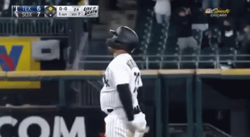 A Baseball Player Wearing A Black Helmet Is Standing On The Field . GIF