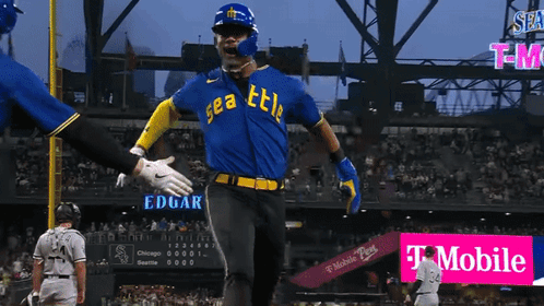 A Baseball Player Wearing A Blue And Yellow Seattle Jersey Celebrates GIF