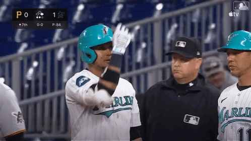 A Baseball Player Wearing A Blue Helmet Is Talking To A Referee GIF