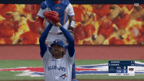 A Baseball Player Wearing A Blue Jays Jersey Stands On A Baseball Field GIF