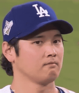 A Baseball Player Wearing A Blue La Hat Is Making A Face . GIF
