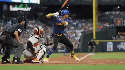 A Baseball Player Wearing A Blue Sea Jersey Swings His Bat GIF