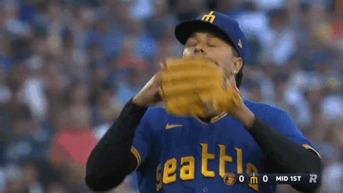 A Baseball Player Wearing A Blue Seattle Jersey Holds His Glove GIF