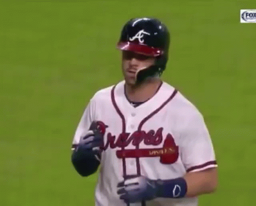 A Baseball Player Wearing A Braves Jersey Holds His Hand To His Face GIF