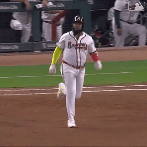 A Baseball Player Wearing A Braves Jersey Is Running Towards Home Plate GIF