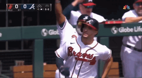 A Baseball Player Wearing A Braves Jersey Stands In Front Of A Globe Life Sign GIF