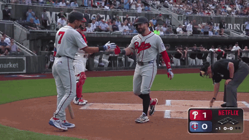 a baseball player wearing a braves uniform is congratulating another player