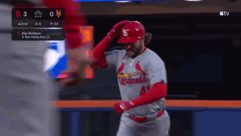 A Baseball Player Wearing A Cardinals Uniform Is Standing In The Outfield . GIF